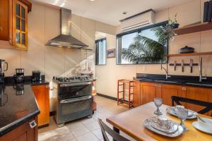 a kitchen with a table and a stove top oven at Mansão em Niterói com Piscina e Vista Mar | LD 58 in Icaraí