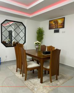 a dining room table with chairs and a mirror at Coastal Gem 3BR, Pool, 5 Min Walk to Beach - Nyali in Nyali