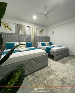 two beds in a room with blue pillows at Coastal Gem 3BR, Pool, 5 Min Walk to Beach - Nyali in Nyali +9 photos