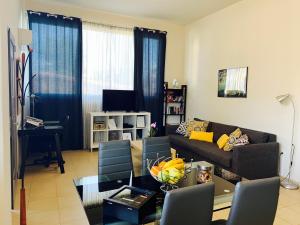 a living room with a couch and a table at Nefele - Athens Airport Home in Artemida