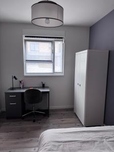 a bedroom with a desk and a chair and a window at Appart Wavre, 2ch, terrasse, piscine, charme & confort in Wavre