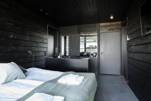 una camera da letto con un letto grande e una cucina di Maisemasviitit Ellivuori Resort a Karkku