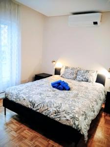 Schlafzimmer mit einem Bett und einem blauen Bademantel in der Unterkunft Casa com jardim privado e estacionamento no interior in Amares