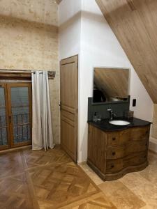 a bathroom with a sink and a wooden cabinet at Le Relai Valdieu in Courgeon