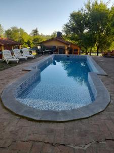 a large swimming pool with chairs around it at Cabañas Sensaciones Serranas in Casa Grande