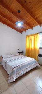 a bedroom with a bed with a yellow curtain at Cabañas Sensaciones Serranas in Casa Grande