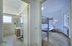 a room with a bunk bed and a bathroom with a sink at Casa Giuditta with Air Conditioning and Pool in Lierna