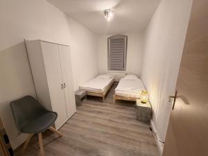 a small room with two beds and a chair at Apartment DENISA in Gera