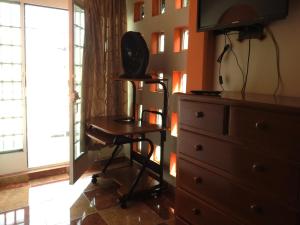 a room with a dresser and a desk and a television at MJ Habitaciones Cholula in La Concepción