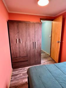 ein Schlafzimmer mit einem großen Holzschrank neben einem Bett in der Unterkunft Casa Tres Hermanos in Carmelo