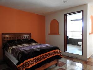 a bedroom with a bed and a mirror and a tub at MJ Habitaciones Cholula in La Concepción