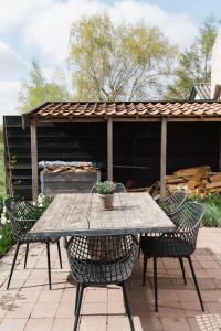 een houten tafel en stoelen met een tafel en een pergola bij Hof Driewegen in Driewegen