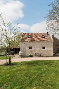 een groot stenen gebouw met een rood dak bij Hof Driewegen in Driewegen