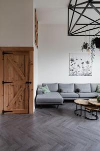 een woonkamer met een bank en een houten deur bij Hof Driewegen in Driewegen +36 foto's