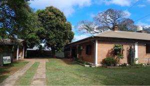 an old brick house with a grass yard at Madre America Hotel & Hostel in San Ignacio
