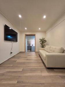 a living room with a couch and a flat screen tv at AH Residencial in Antofagasta