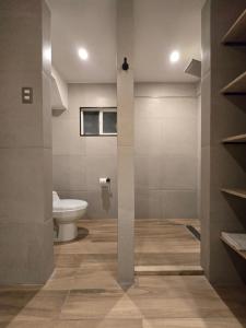 a bathroom with a toilet and a wall with shelves at AH Residencial in Antofagasta +17 photos