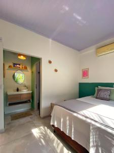 a bedroom with a large bed and a sink at Suítes Preguiça in Sao Jorge +25 photos