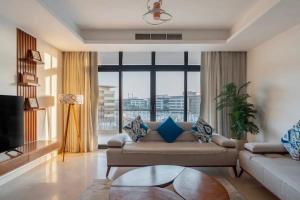 a living room with a couch and a large window at Luxury Apartments in Cairo Festival City in Cairo