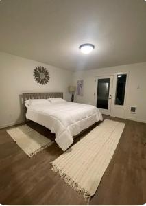 a bedroom with a large white bed and a rug at Home at Kingwood in Forest Grove in Forest Grove