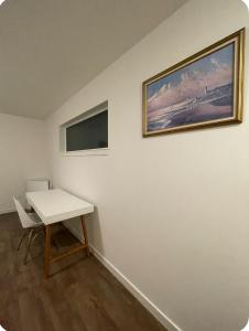a white room with a table and a painting on the wall at Home at Kingwood in Forest Grove in Forest Grove