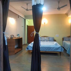 Un dormitorio con una cama con sábanas y cortinas azules. en SL Guest House, en Mawlynnong