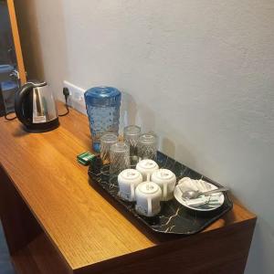 una bandeja con cuatro velas sobre una mesa de madera en SL Guest House, en Mawlynnong