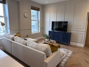 un salon avec un canapé et une télévision dans l'établissement Luxury 2Bed 2 Bath Apartment in Historic Bank, à Leyburn