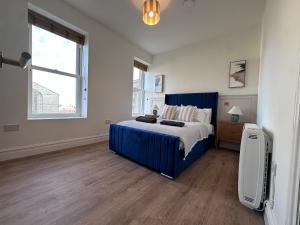 une chambre avec un lit bleu et une fenêtre dans l'établissement Luxury 2Bed 2 Bath Apartment in Historic Bank, à Leyburn
