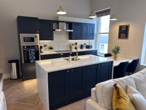 une cuisine avec des placards bleus et un comptoir blanc dans l'établissement Luxury 2Bed 2 Bath Apartment in Historic Bank, à Leyburn