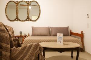 Habitación con sofá, mesa y espejo. en Isthmus Filoxenia, en Istmia