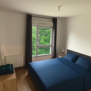 a bedroom with a blue bed and a window at Villeurbanne la soie - Rhône express in Villeurbanne