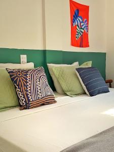a bed with several pillows on it in a room at Suítes Preguiça in Sao Jorge