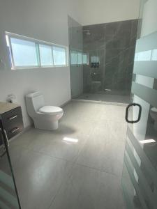 a bathroom with a toilet and a shower with a glass door at Hotel Casa Bendicion in Los Limones