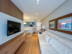 圣劳伦斯海滨Riviera | Vista Mar Pé na Areia - Enxoval Completo的客厅配有白色沙发和平面电视。