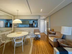 圣劳伦斯海滨Riviera | Vista Mar Pé na Areia - Enxoval Completo的配有桌椅的客厅和餐厅
