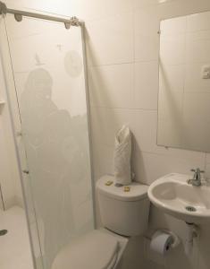 a bathroom with a toilet and a sink at Hotel Kasvel in Valledupar