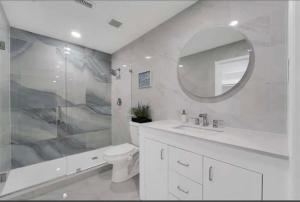 a white bathroom with a sink and a mirror at Spacious 3BR Oasis Pool Fire Pit & Family Fun in Cowley