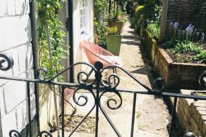 ein schmiedeeiserner Zaun vor einem Garten in der Unterkunft Mews Cottage off Marlborough High Street in Marlborough + 10 Fotos