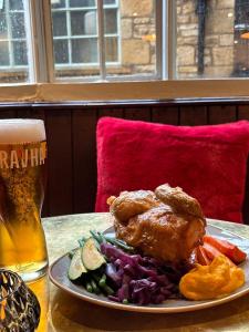 a plate with meat and vegetables and a glass of beer at The Red lion in Gloucestershire +17 photos