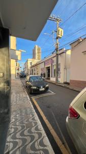 a car parked on the side of a city street at Hotel Dourado in Alfenas