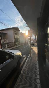 a car parked on a street with a no parking sign at Hotel Dourado in Alfenas