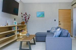 ein Wohnzimmer mit einem blauen Sofa und einem Tisch in der Unterkunft TerraCondos Loft 203 & 204 in Bahías de Huatulco