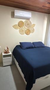 ein Schlafzimmer mit einem blauen Bett und einem Ventilator in der Unterkunft Casa Hygge - Conforto, estilo e momentos únicos! in Tamandaré
