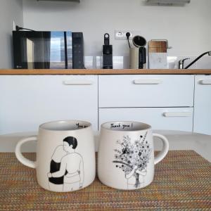 zwei Kaffeetassen stehen auf einer Theke in einer Küche in der Unterkunft Bolhão Skyline in Porto