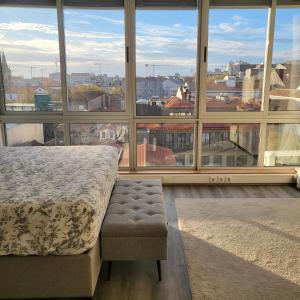 ein Schlafzimmer mit einem Bett und einem großen Fenster in der Unterkunft Bolhão Skyline in Porto + 15 Fotos