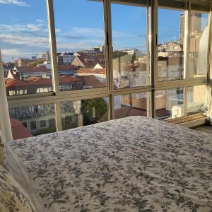 a bedroom with a view of a city from a window at Bolhão Skyline in Porto