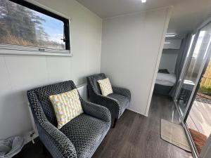 BallynameenにあるThe Little Pod - Forest Viewのリビングルーム(椅子2脚、窓付) +4枚の写真