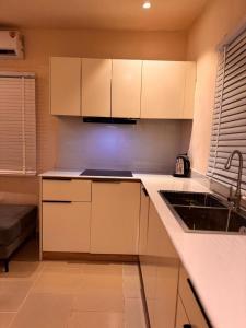 a kitchen with white cabinets and a sink at One Bedroom Studio Apartment in Benin City