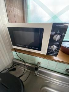 a microwave sitting on a shelf above a sink at 九州 福岡 貸切 プライベートハウス 
